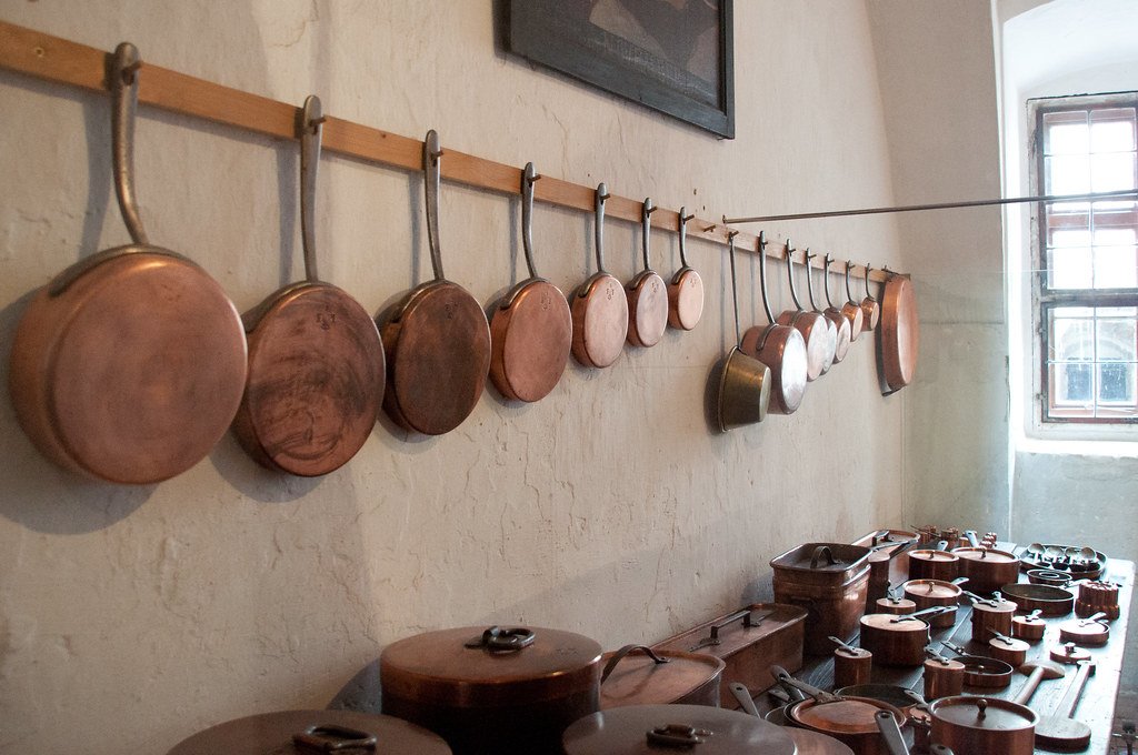 Copper cookware hanging on a kitchen wall
